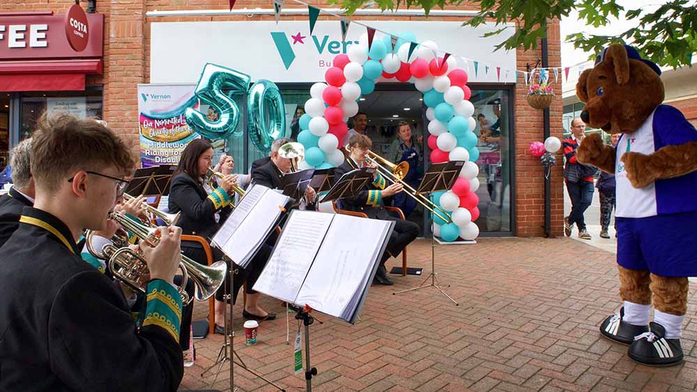 Vernon Bear in front of Poynton Brass Band
